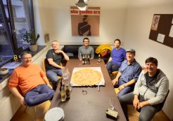 2. Treffen der Drupal User Group Bodensee Sechs Drupal-Entwickler der User Group Bodensee sitzen um einen Tisch, in der Mitte liegt eine große Pizza