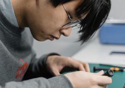 Photo by Tima Miroshnichenko: https://www.pexels.com/photo/a-man-in-gray-sweater-sitting-at-the-table-6754852/ An engineer works on an electronic component